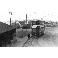 Black and white photograph of Granton Square with a tram in the foreground and a train and the harbour in the background