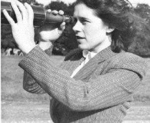 Black and white photograph of Mary Brück looking through a telescope