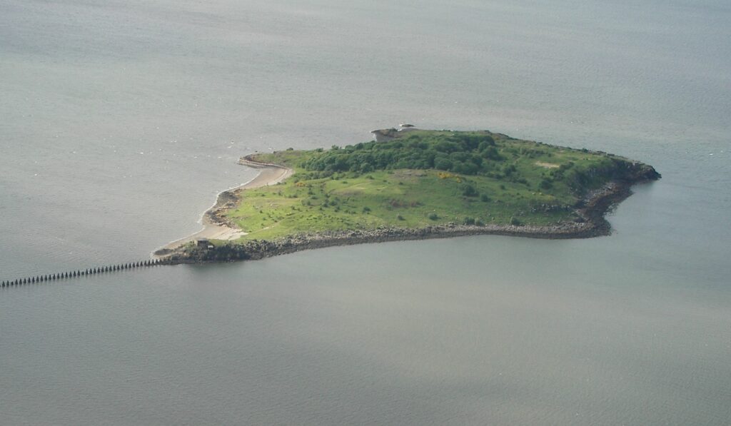 Green island surrounded by blue-grey water.