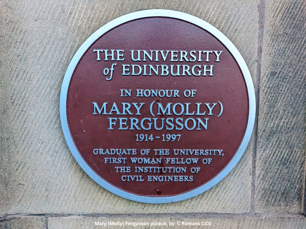A dark red circular plaque with white lettering that reads “The University of Edinburgh in honour of Mary (Molly) Fergusson 1914-1997, graduate of the university, first woman fellow of the institution of civil engineers.”