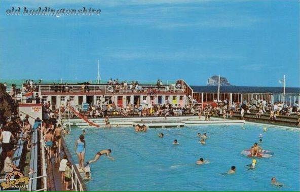 Old-time photo of a pool with people swimming.