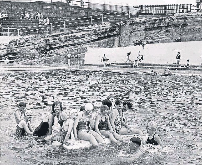 Black and white image of swimmers on a raft and in the tidal pool.