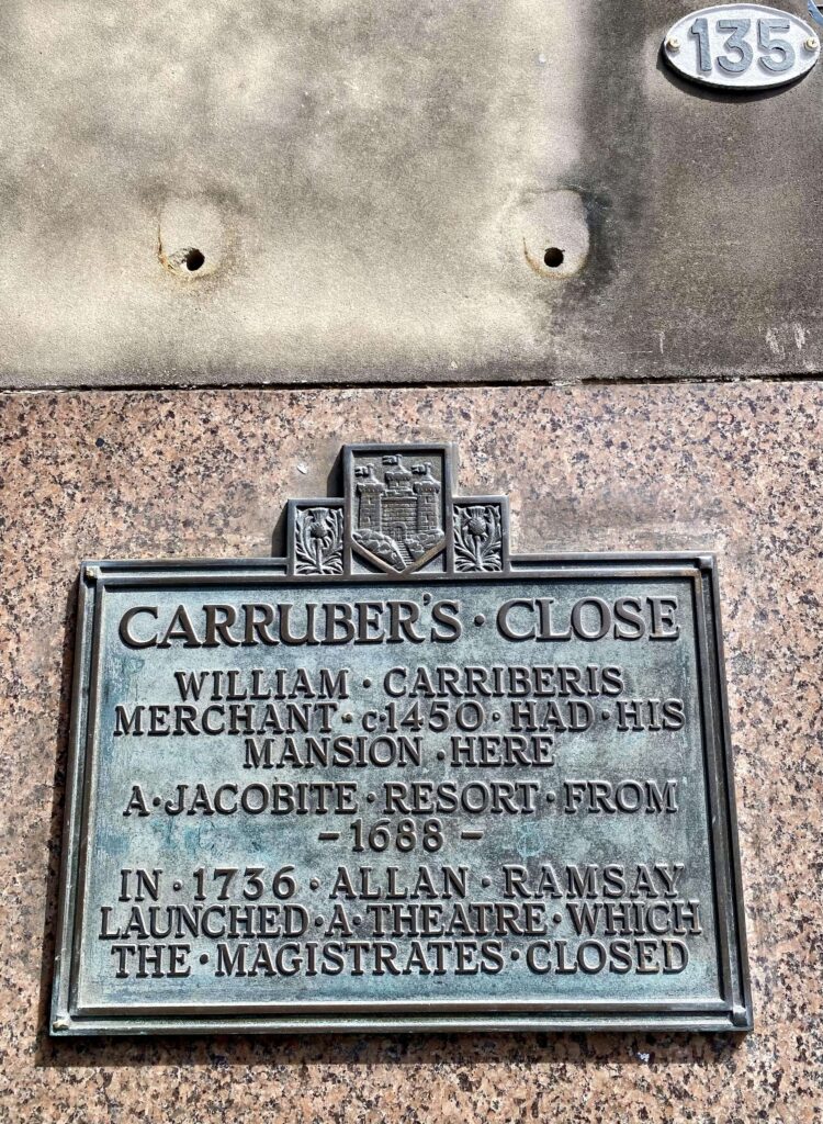 Bronze plaque at the entry of Carrubber's Close; plaque is adorned with thistles and a castle.