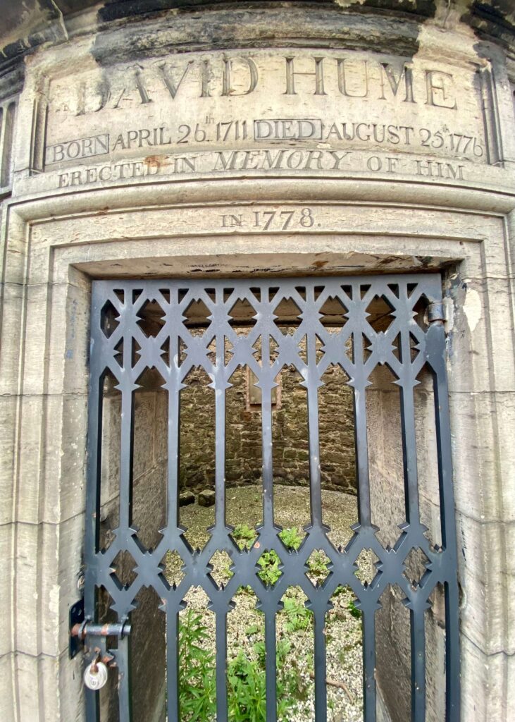 David Hume memorial engraving atop black iron gate.