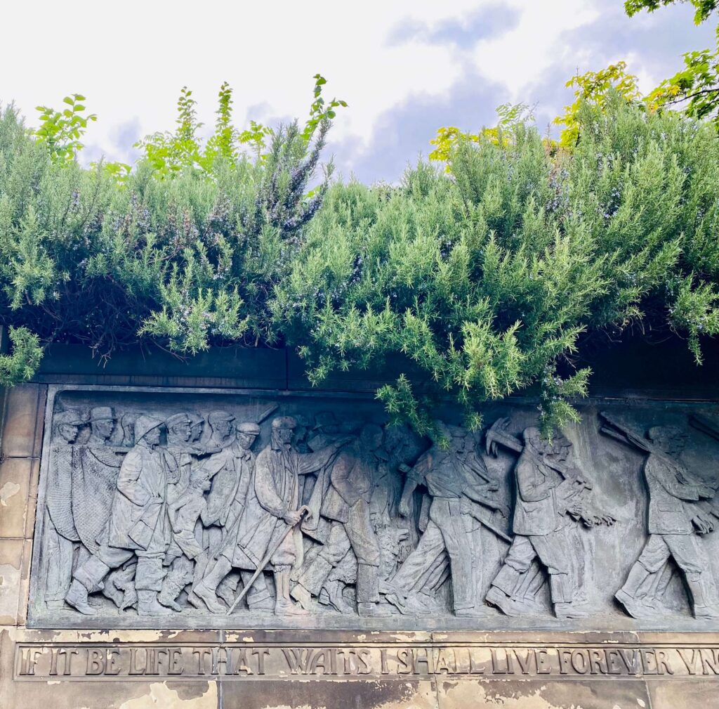 Relief of everyday Scots walking carrying items like canes and tools.