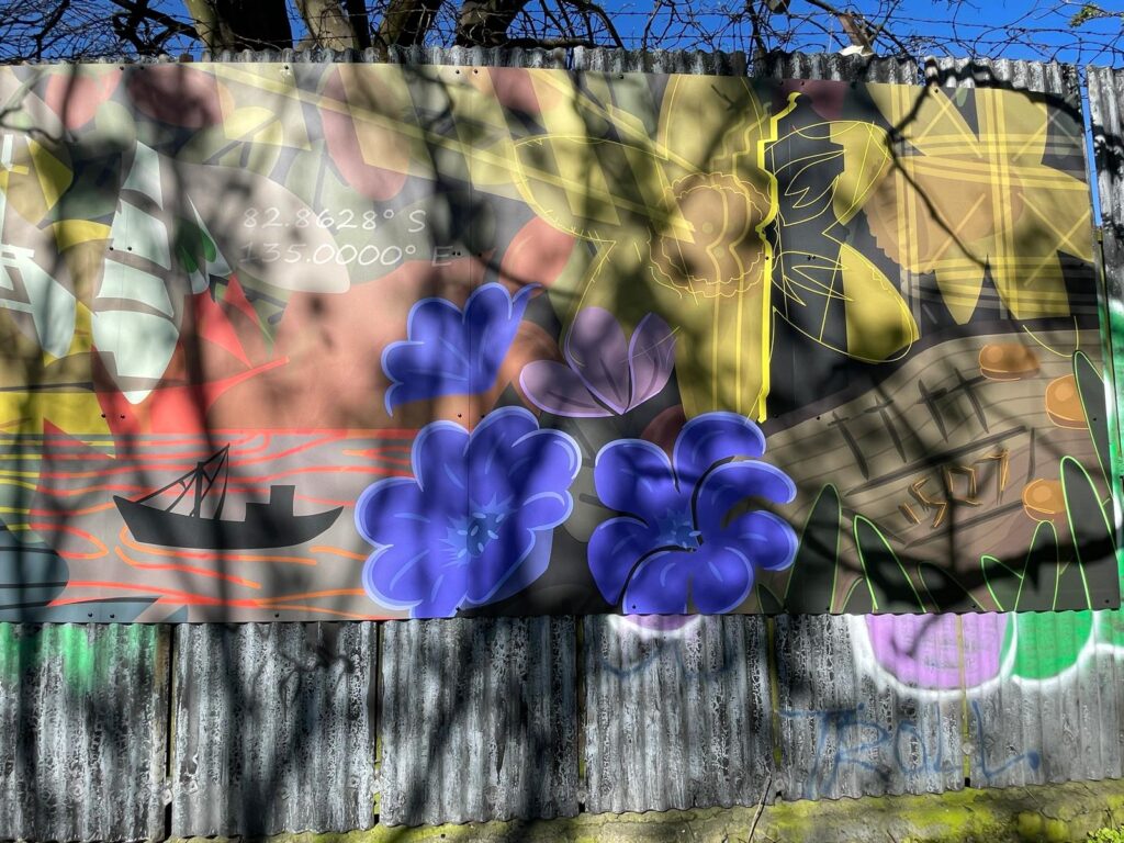 Colorful horizontal mural with purple and yellow flowers, a black boat, and the date 1507.